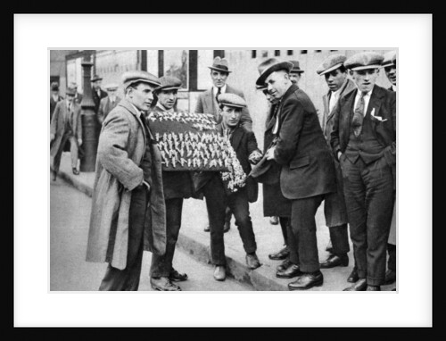 Street hawker selling football favours in King's Cross, London by Anonymous