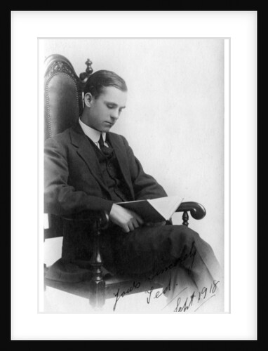 Man sitting in a chair reading a book by Anonymous
