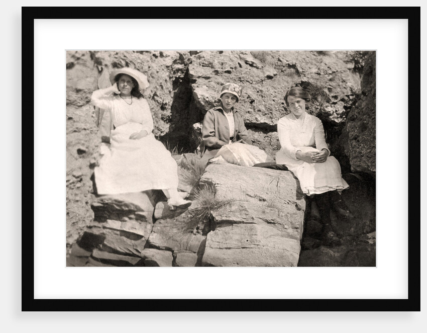 Three women relaxing on rocks by Anonymous