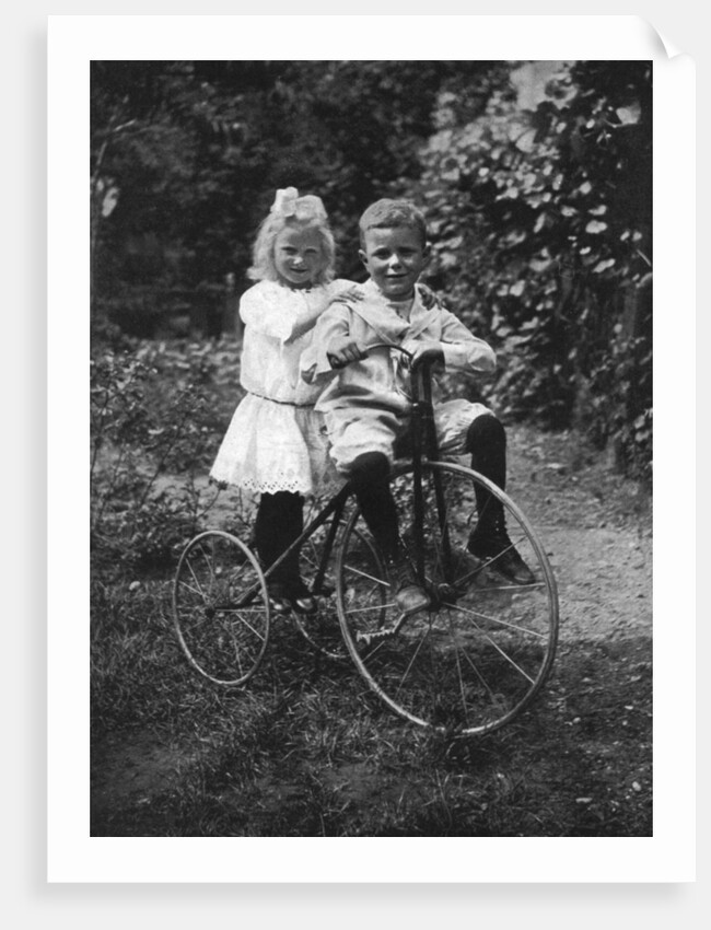 Two children on a tricycle by CW Perry