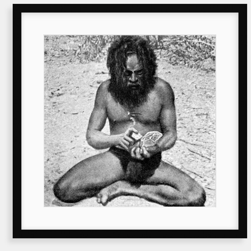 A man from the Warramunga tribe making a stone axe head, Australia by Spencer and Gillen