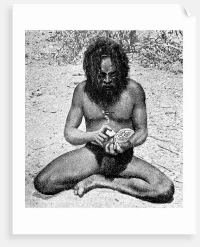 A man from the Warramunga tribe making a stone axe head, Australia by Spencer and Gillen