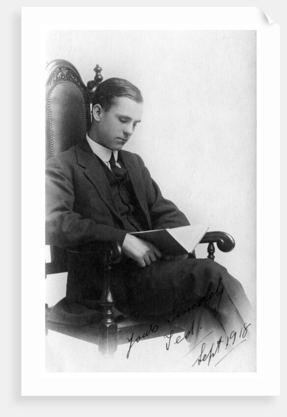 Man sitting in a chair reading a book by Anonymous