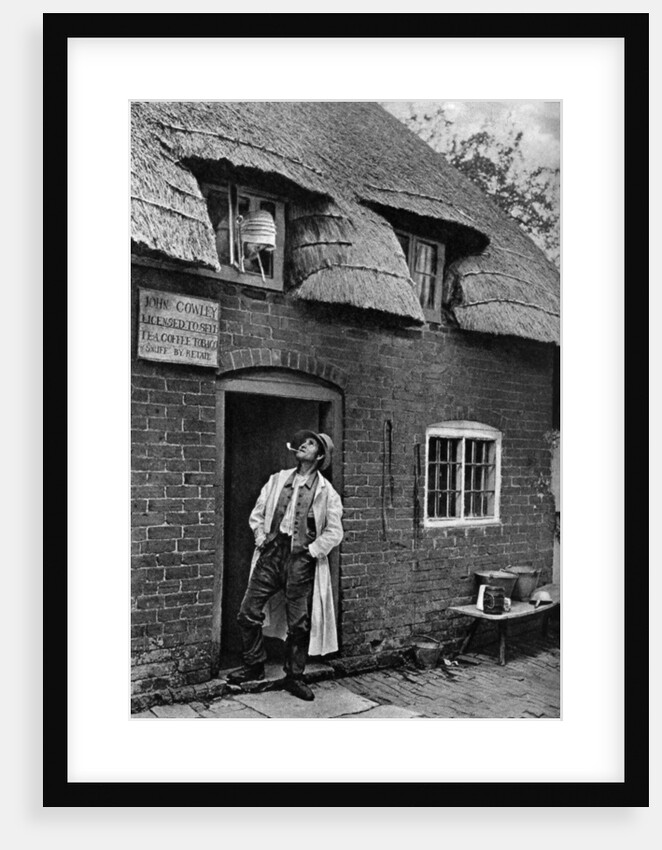 A man smoking a pipe outside a shop, Worcestershire by AW Cutler