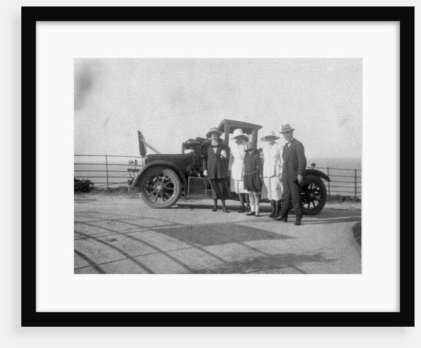 A group of people in front of their car at the seaside by Anonymous