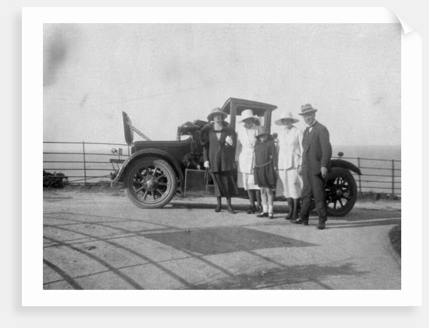 A group of people in front of their car at the seaside by Anonymous