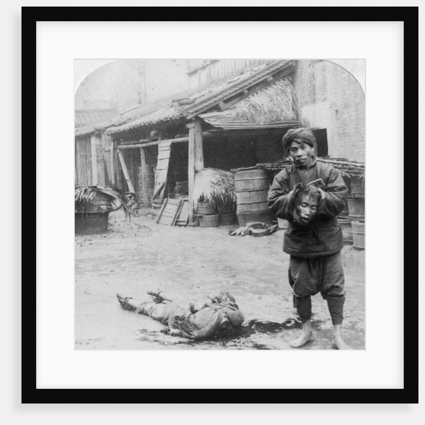 The grim executioner taking the labled head to exhibit a warning by Underwood & Underwood