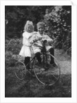 Two children on a tricycle by CW Perry