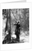 Pygmy tree dweller using a blow-gun, Malaya by Malayan Malayan Information Agency