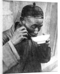 A man eating, Mukden (Shenyang), China by Wide World Photos