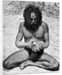 A man from the Warramunga tribe making a stone axe head, Australia by Spencer and Gillen