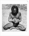 A man from the Warramunga tribe making a stone axe head, Australia by Spencer and Gillen