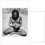 A man from the Warramunga tribe making a stone axe head, Australia by Spencer and Gillen