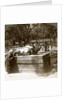 Devout woman stroking a bronze bull to cure rheumatism, Kitano Tenjin temple, Kyoto, Japan by Underwood & Underwood
