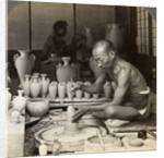 A potter and his wheel, fashioning a vase of Awata porcelain, Kinkosan works, Kyoto, Japan by Underwood & Underwood