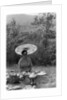 Woman under a parasol having a picnic by Anonymous