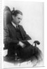Man sitting in a chair reading a book by Anonymous
