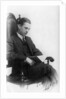 Man sitting in a chair reading a book by Anonymous