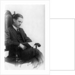 Man sitting in a chair reading a book by Anonymous