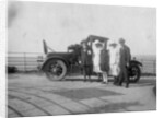 A group of people in front of their car at the seaside by Anonymous