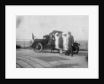 A group of people in front of their car at the seaside by Anonymous
