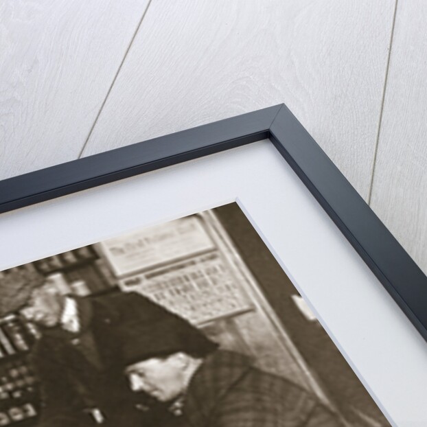 A group of men around a stove in a shop by Anonymous