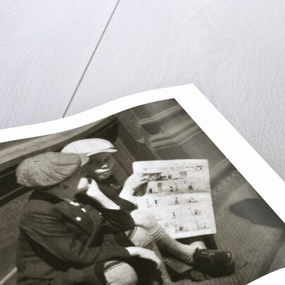 Two boys reading the comic section of the Sunday paper by Anonymous