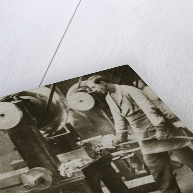 Money making; cutting strips of silver into disks by Anonymous