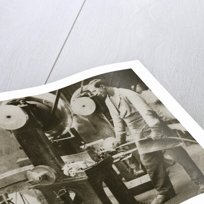 Money making; cutting strips of silver into disks by Anonymous