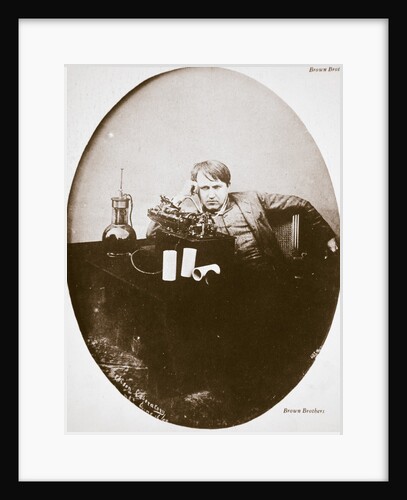 Thomas Alva Edison, American inventor, sitting beside his improved machine by Anonymous