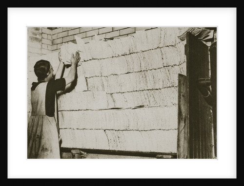 Stacking unleavened bread for the Passover in a Jewish bakery by Anonymous