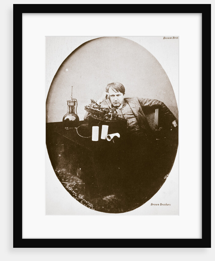 Thomas Alva Edison, American inventor, sitting beside his improved machine by Anonymous
