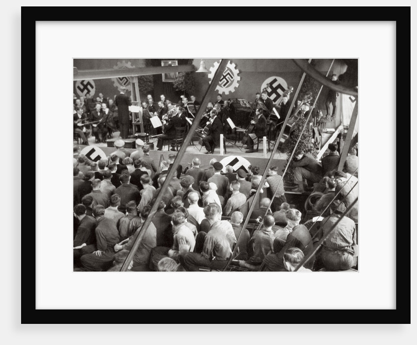 An orchestra plays to some factory workers as they take a break from work by Anonymous