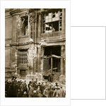 A crowd of men gathered in front of a ruined building by Anonymous