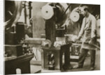 Money making; cutting strips of silver into disks by Anonymous