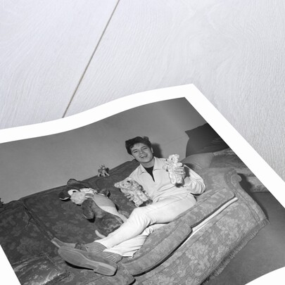 Cliff Richard on a sofa with soft toys by Harry Hammond
