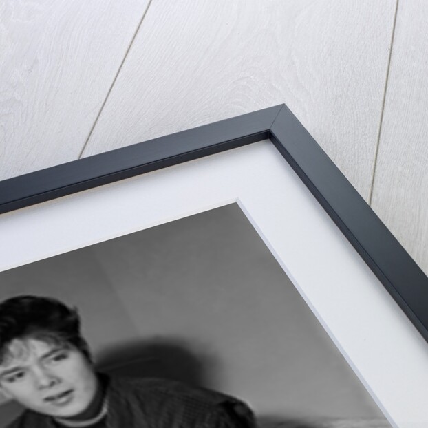 Cliff Richard in his first house sitting on a bed by Harry Hammond