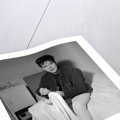 Cliff Richard in his first house sitting on a bed by Harry Hammond