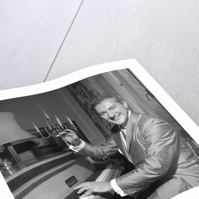 Liberace playing the piano at the Savoy Hotel by Harry Hammond