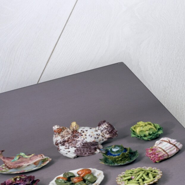 Arrangement of ceramic tureens and trick plates in the shape of vegetables and other food by Unknown
