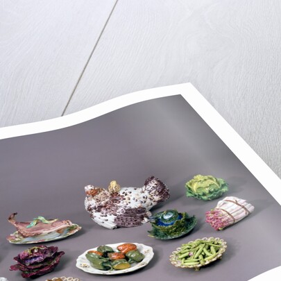 Arrangement of ceramic tureens and trick plates in the shape of vegetables and other food by Unknown