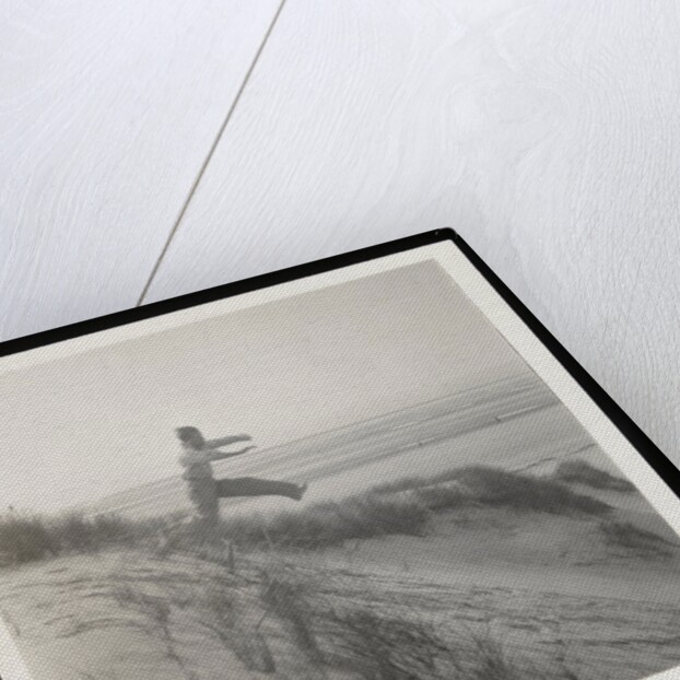 Man jumping off sand dune by Curtis Moffat