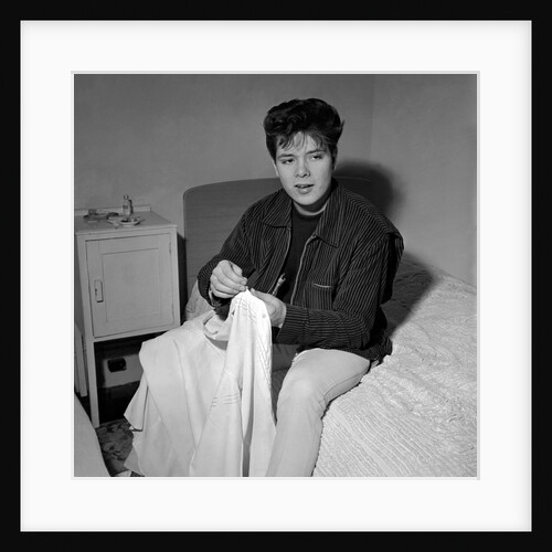 Cliff Richard in his first house sitting on a bed by Harry Hammond