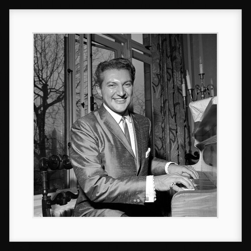 Liberace playing the piano at the Savoy Hotel by Harry Hammond