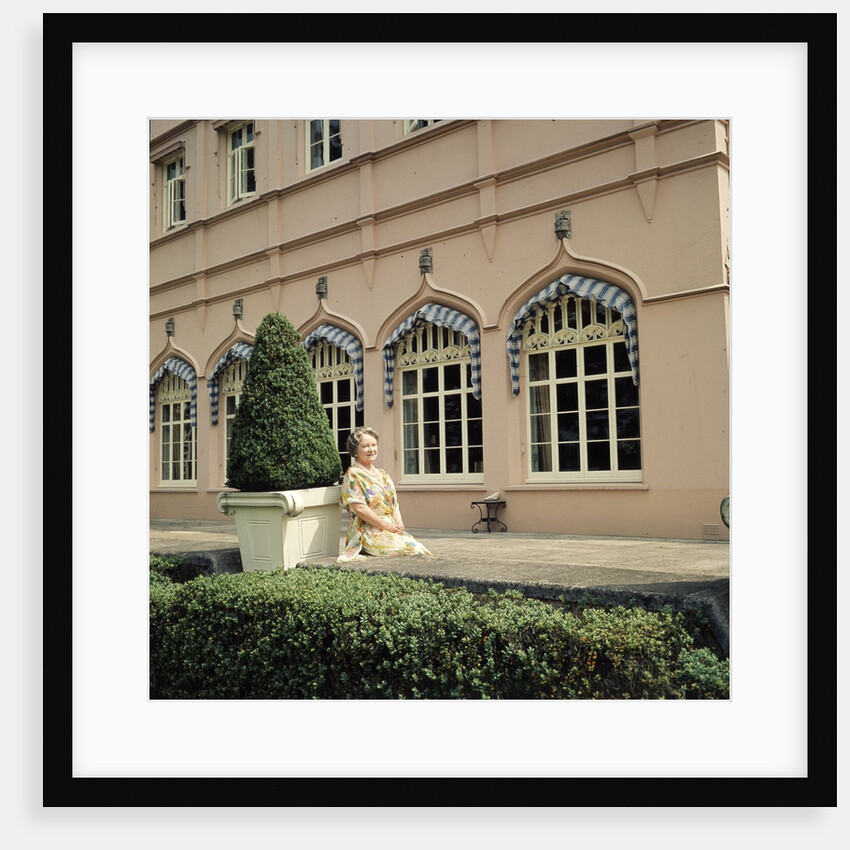 Queen Elizabeth, The Queen Mother sitting in the gardens at Windsor Great Park by Cecil Beaton
