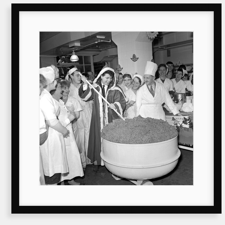 Cliff Richard mixing a giant Christmas pudding at J.Lyons in Cadby Hall, Hammersmith by Harry Hammond