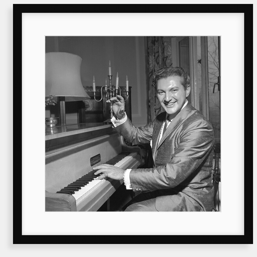 Liberace playing the piano at the Savoy Hotel by Harry Hammond