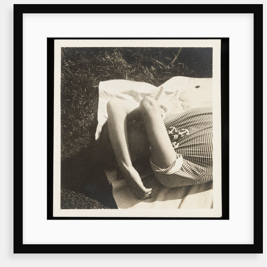 Woman wearing striped t-shirt lying on rug with both arms covering face by Curtis Moffat
