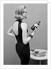 Model holding bottle of poison by John French