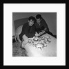 Cliff Richard looking some promotional photographs by Harry Hammond